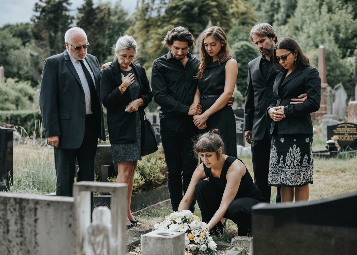 family lays flowers at graveside 233511519