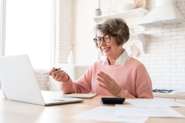 Older woman completes taxes online 708174038