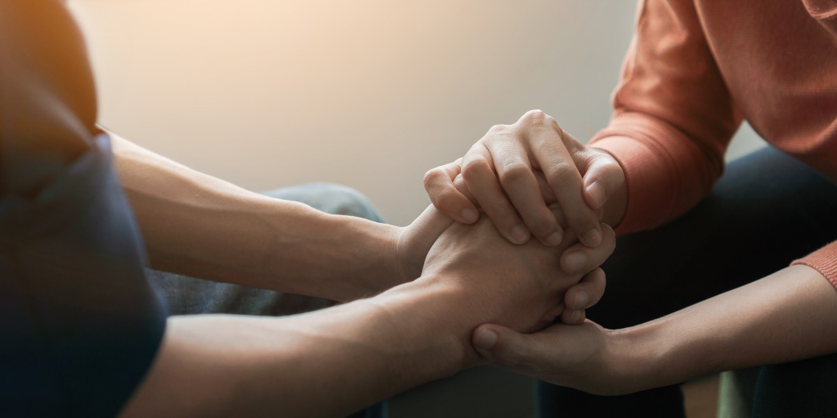 Couple holding hands while discussing final expense insurance.