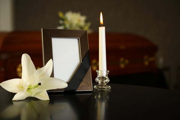 Funeral arrangements with a candle and a white flower