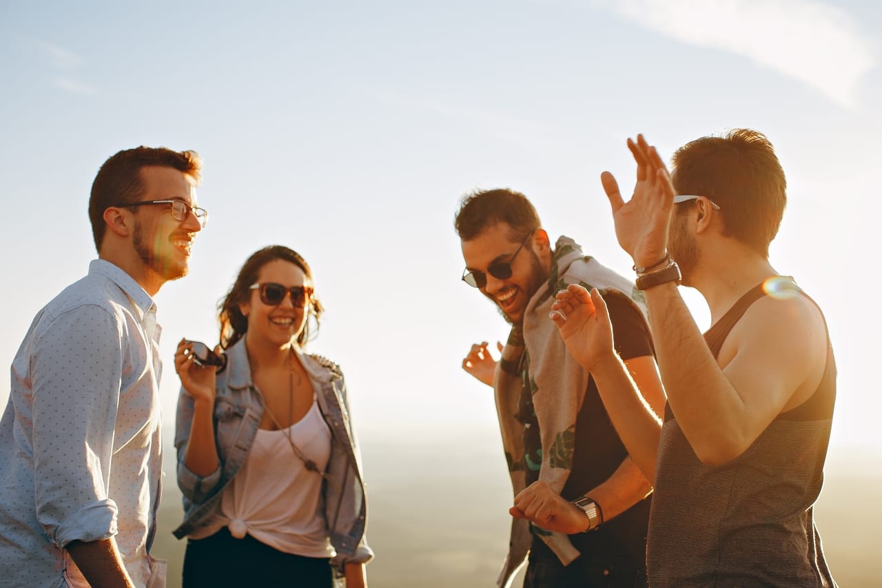 three men and one woman laughing together