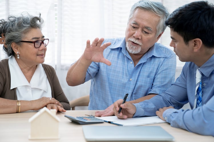 elderly couple discussing insurance prices with insurance agent