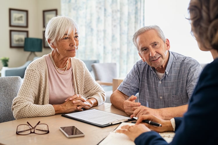 Elderly couple discussing preneed funeral planning with insurance agent
