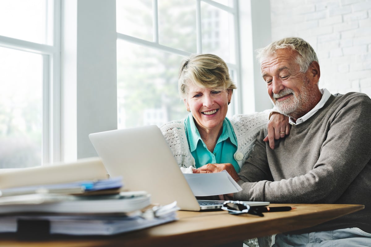 a couple reads about fixed rate and variable rate annuities on their laptop